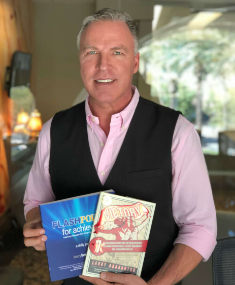 photo of Larry Broughton holding two books